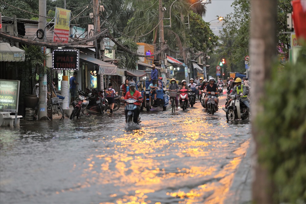 Khoảng 17h, triều cường bắt đầu dâng cao, nước từ các miệng cống dâng lên gây ngập một số đoạn, nhất là khu vực gần cầu Rạch Tôm. Ảnh: Trường Sơn