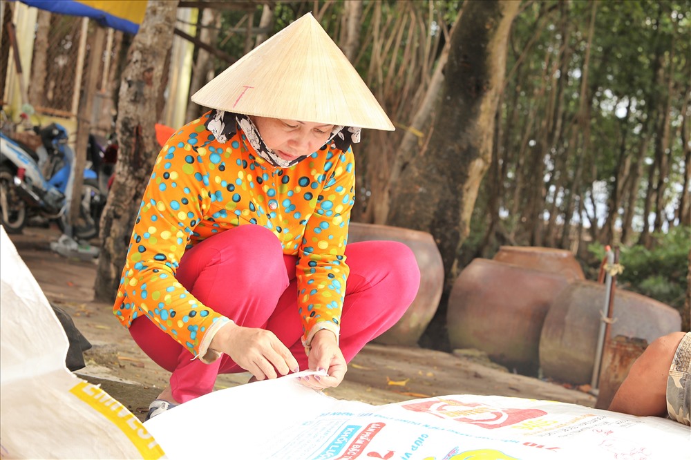 Bên cạnh nghề đánh bắt thủy sản và làm muối, mấy năm nay người dân Thạnh An phát triển thêm nghề nuôi hàu. Trong ảnh là một phụ nữ đang khẩn trương chuẩn bị các công cụ để bắt tay trở lại với công việc sau mấy ngày đi trú bão. Ảnh: Trường Sơn