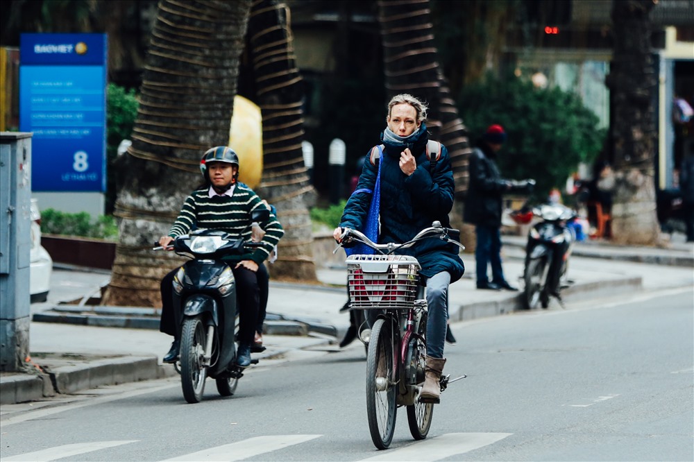 Du khách nước ngoài túm cổ áo để tránh gió lạnh lùa vào người.