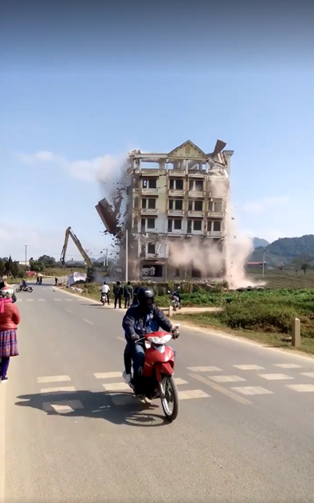 một phần của căn nhà đã đổ ấp xuống chiếc máy xúc.