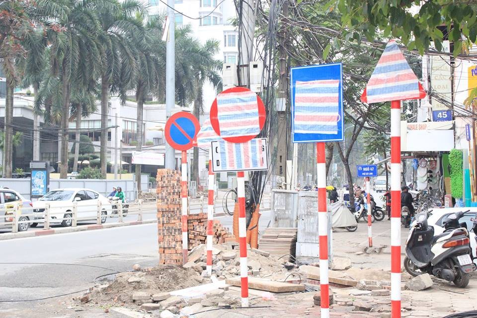 Những biển cấm được che kín bởi tấm bạt kẻ.