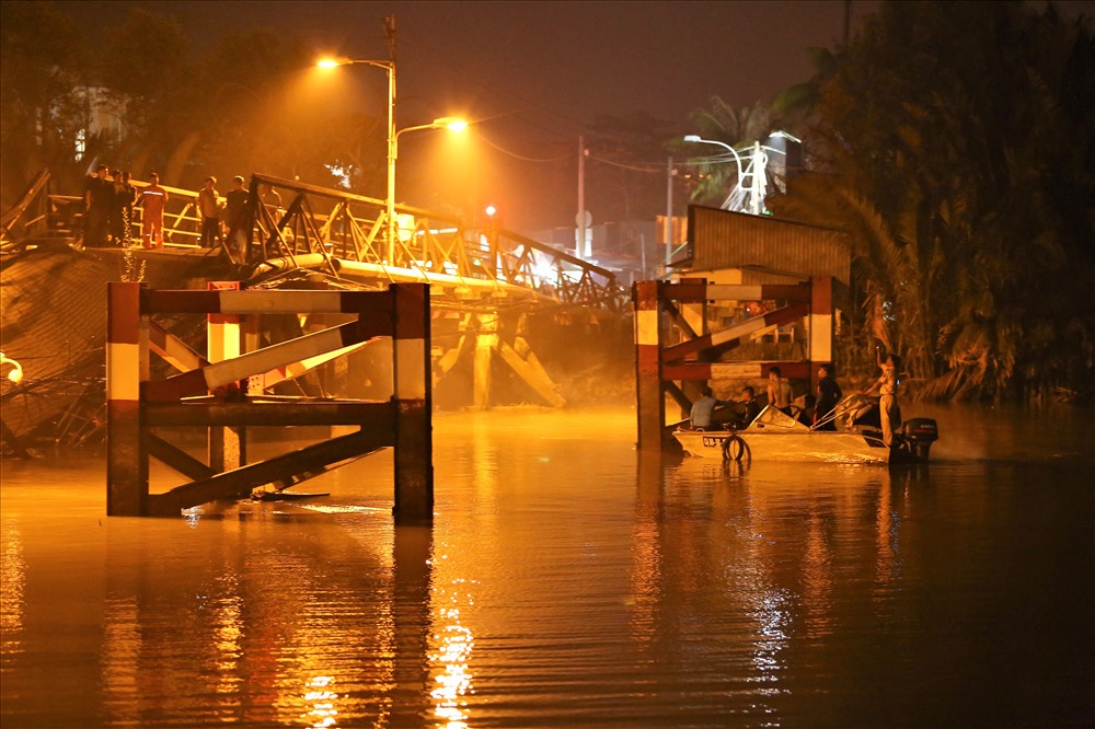 Người dân cho biết, lúc xe tải chạy qua thì phát sinh tiếng động lớn. Ngay sau đó, xe tải cùng 1 xe máy bị rơi xuống sông, một mô tô bị mắc lại trên cầu. Hiện vẫn chưa xác định được những người này tình trạng ra sao nhưng có tin cho rằng tài xế xe tải và 2 người đi xe gắn máy đã an toàn. Ảnh: Trường Sơn