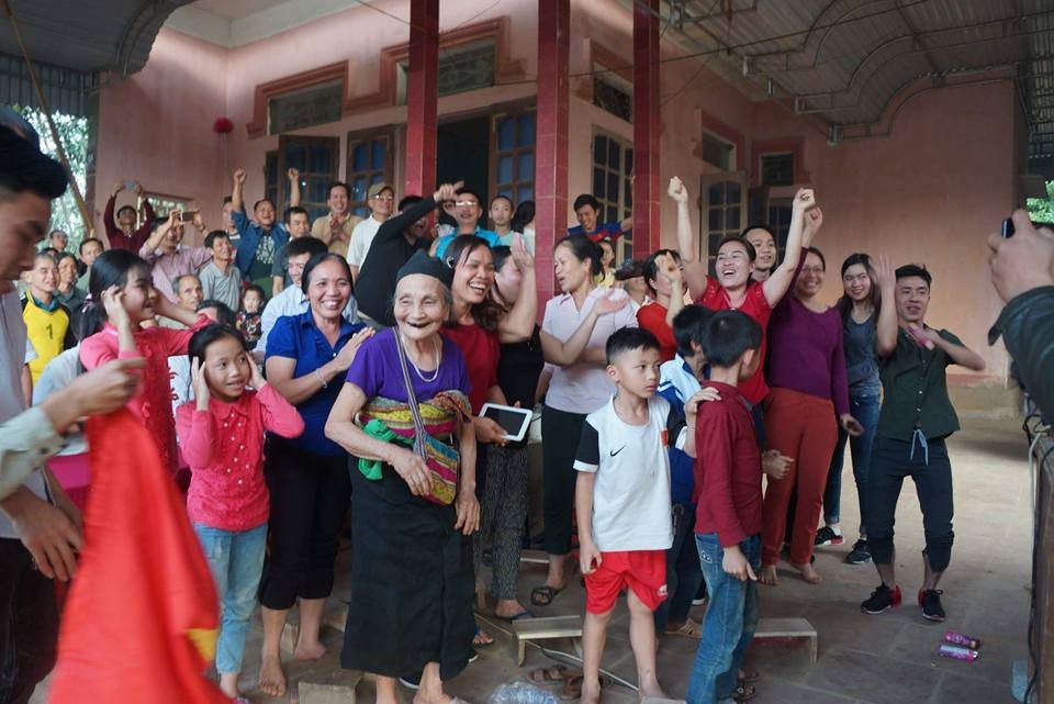 Bà nội Tiến Dũng được cả làng vây quanh chúc mừng khi kết thúc trận đấu.