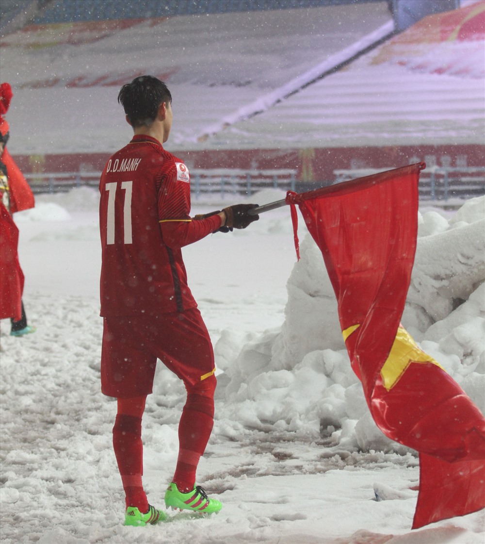 Duy Mạnh cầm lá cờ để cắm lên đụn tuyết cao. Ảnh: Linh Hoàng