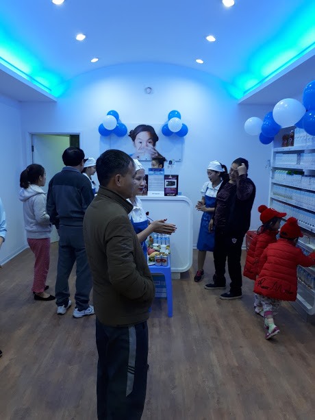 Nhân viên cửa hàng đang giới thiệu đến khách hàng các dòng sản phẩm của Tập đoàn TH.
