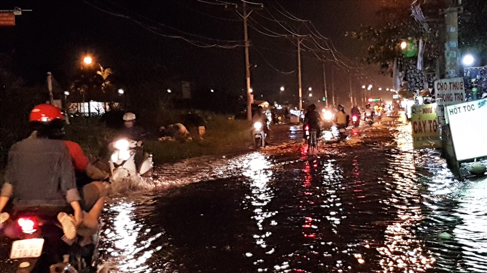 Người dân nơi đây cho biết, cứ mỗi kỳ triều cường thì nước con rạch Bà Tiếng (đoạn chảy ngang qua cầu Bà Tiếng) và từ bãi đất ngập nước bên kia đường Hồ Học Lãm tràn lên gây ngập đường ít nhất trong vài giờ đồng hồ mới chịu rút. Ảnh: Trường Sơn