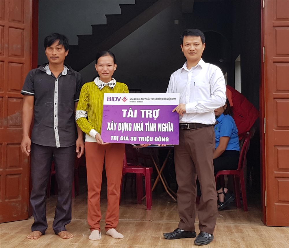 Đại diện Ngân hàng TMCP Đầu tư và Phát triển Việt Nam chi nhánh Ninh Bình trao tiền hỗ trợ cho gia đình chị Lương Thị Thanh Quê. Ảnh: NT