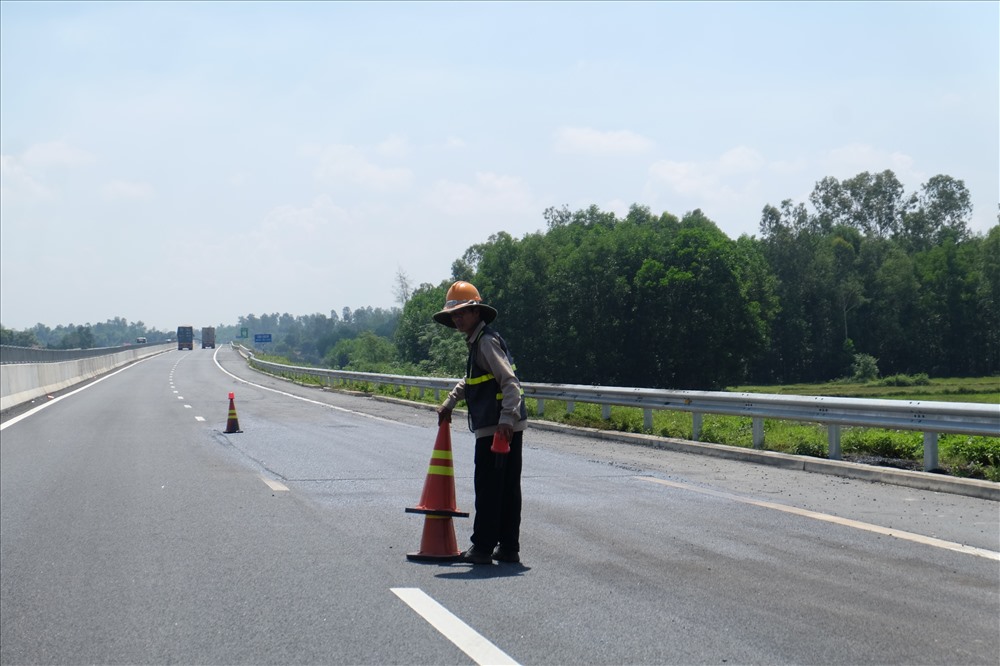 Các công nhân đang thu dọn trang thiết bị sửa chữa trên mặt đường sau khi sửa xong.