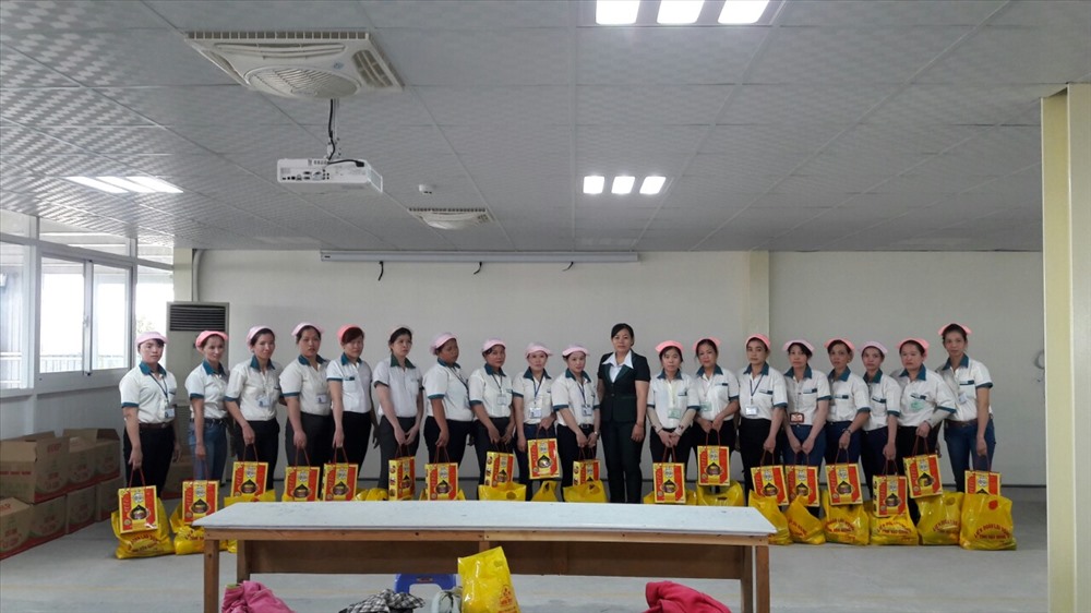 Bà Nguyễn Thị Gọn (áo xanh) trao quà cho CNLĐ trong dịp lễ, tết