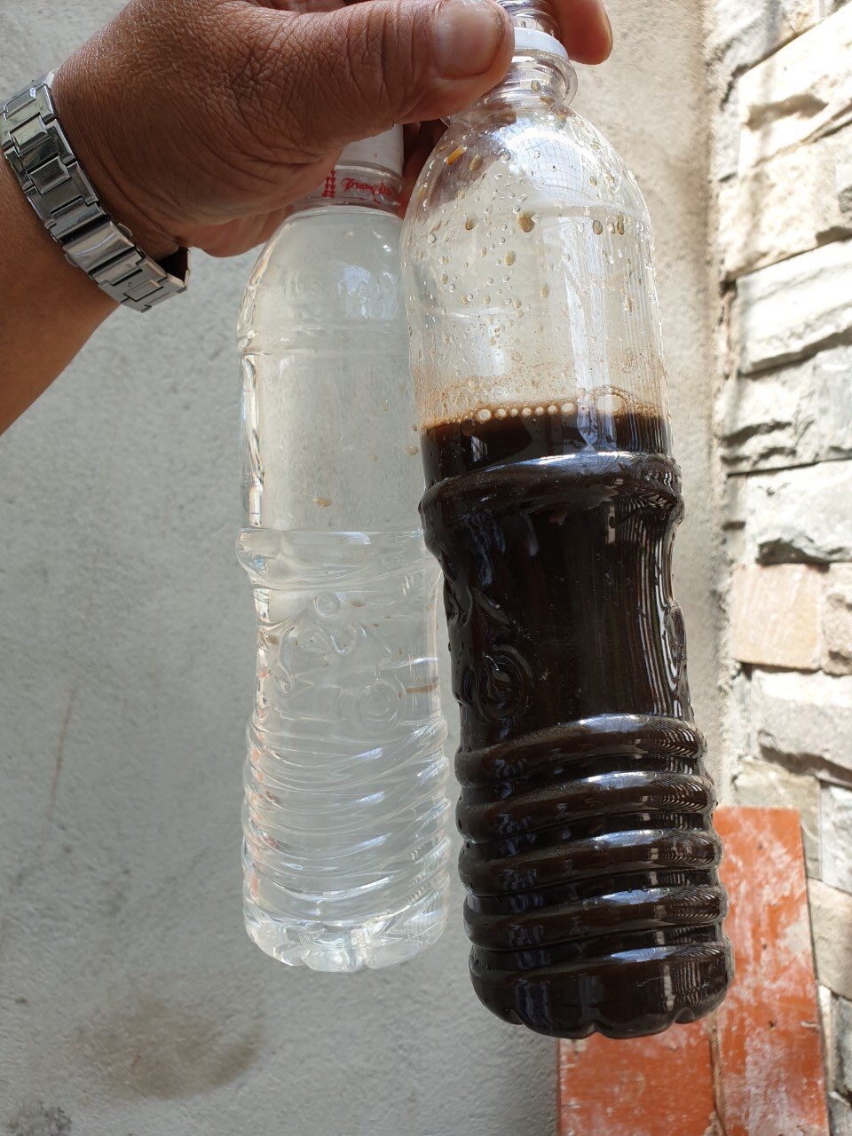 Hình ảnh đối chứng giữa nước thải chưa xử lý (màu đen) và nước thải sau khi được nhà máy của ông Dũng xử lý (chai nước trong). Ảnh: H.H