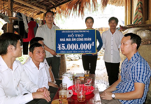 Đồng chí Phạm Sơn - Phó Chủ tịch LĐLĐ tỉnh trao tiền cho đoàn viên Đinh Thị Đắp. 