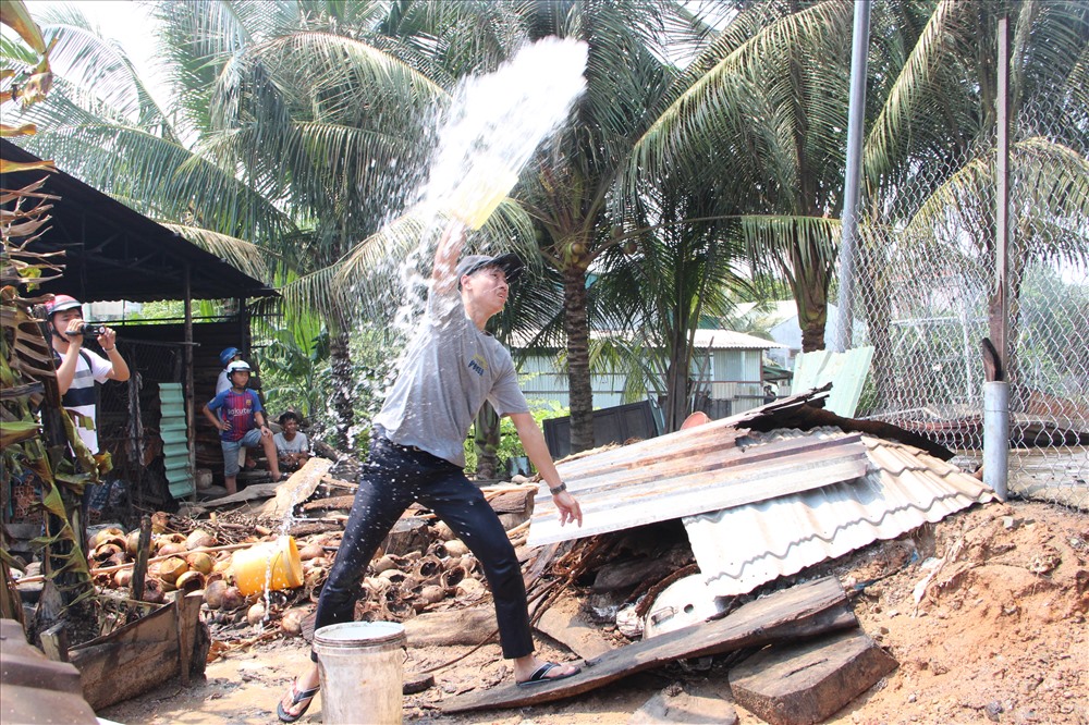 Sợ cháy lan, người dân dùng xô múc nước tạt sang nhà xưởng dập lửa.
