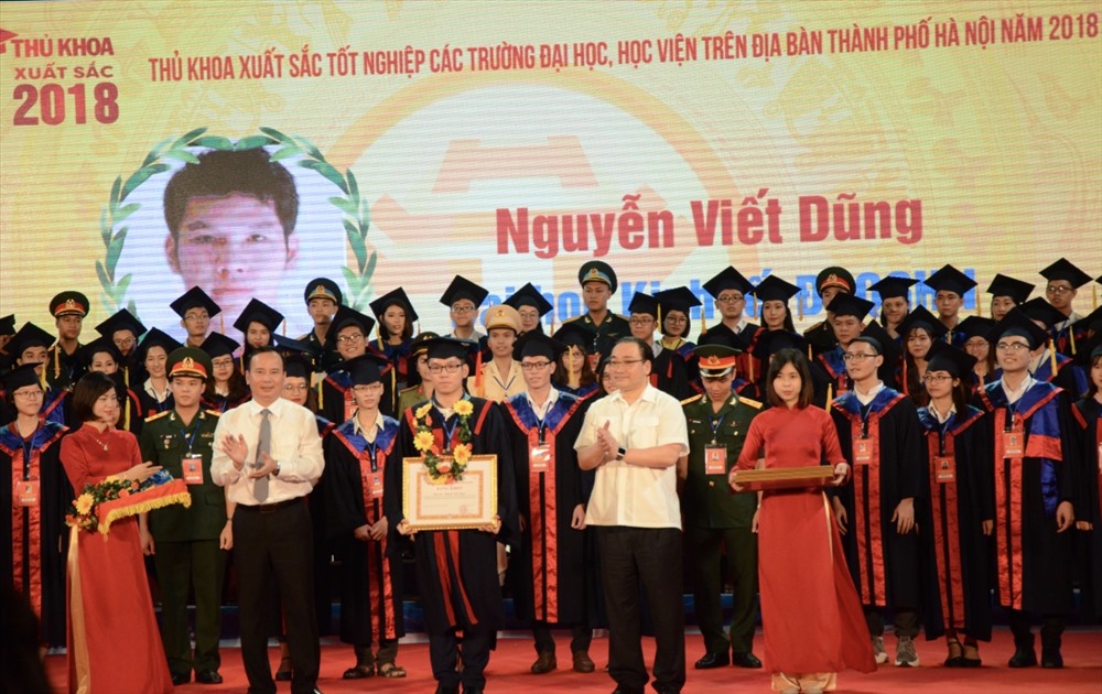 Uỷ viên Bộ Chính trị, Bí thư Thành uỷ Hà Nội Hoàng Trung Hải; Phó Trưởng ban Dân vận Trung ương Nguyễn Lam trao bằng khen và hoa cho các thủ khoa. Ảnh: HN