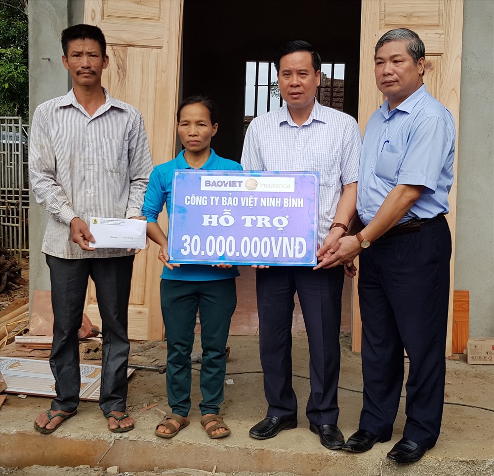 Đại diện lãnh đạo LĐLĐ tỉnh Ninh Bình và trao tiền hỗ trợ cho gia đình chị Lại Thị Hoài. Ảnh: NT