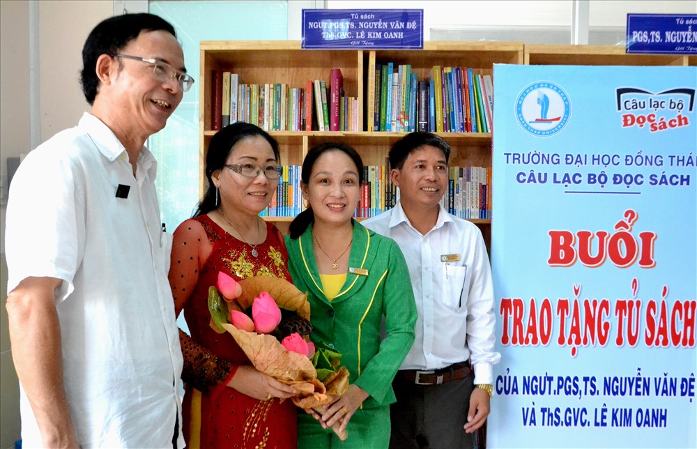 Đại diện CLB Đọc sách tặng hoa thay lời tri ân cho vợ chồng nhà giáo Đệ - Oanh. Ảnh: Lục Tùng