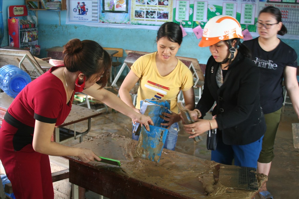 Rất nhiều sách vở của học sinh bị ngâm bùn, cô Nguyễn Thị Minh Hải rưng rưng “sách vở hỏng hết rồi không biết nay mai các em đến trường thế nào đây?“. Ảnh: P.Linh