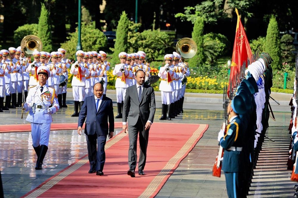 Thủ tướng Nguyễn Xuân Phúc mời Thủ tướng Pháp Édouard Philippe bước lên bục danh dự làm lễ chào cờ. Quân nhạc cử Quốc thiều Việt Nam - Hàn Quốc. Ảnh: Sơn Tùng.