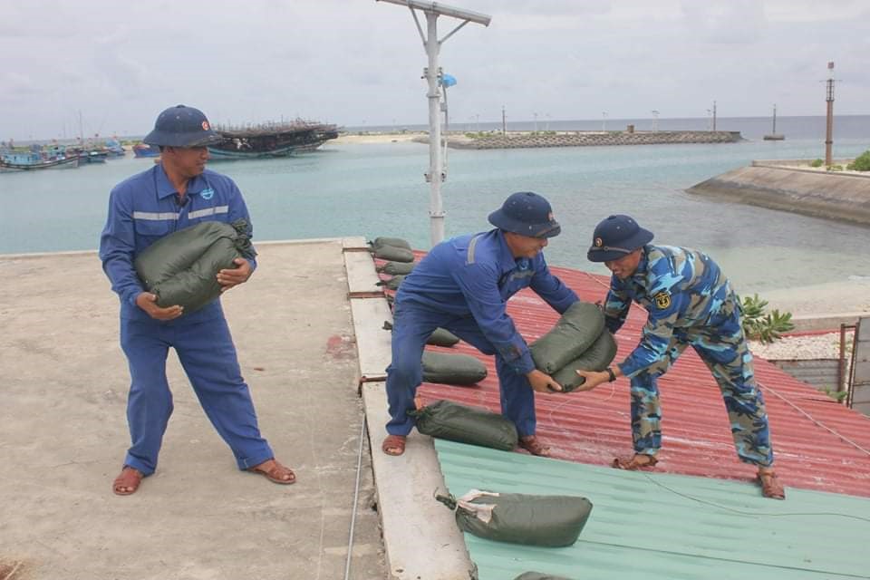Các nhân viên của Trung tâm đang chuyển các bao cát lên mái nhà để chống bão.