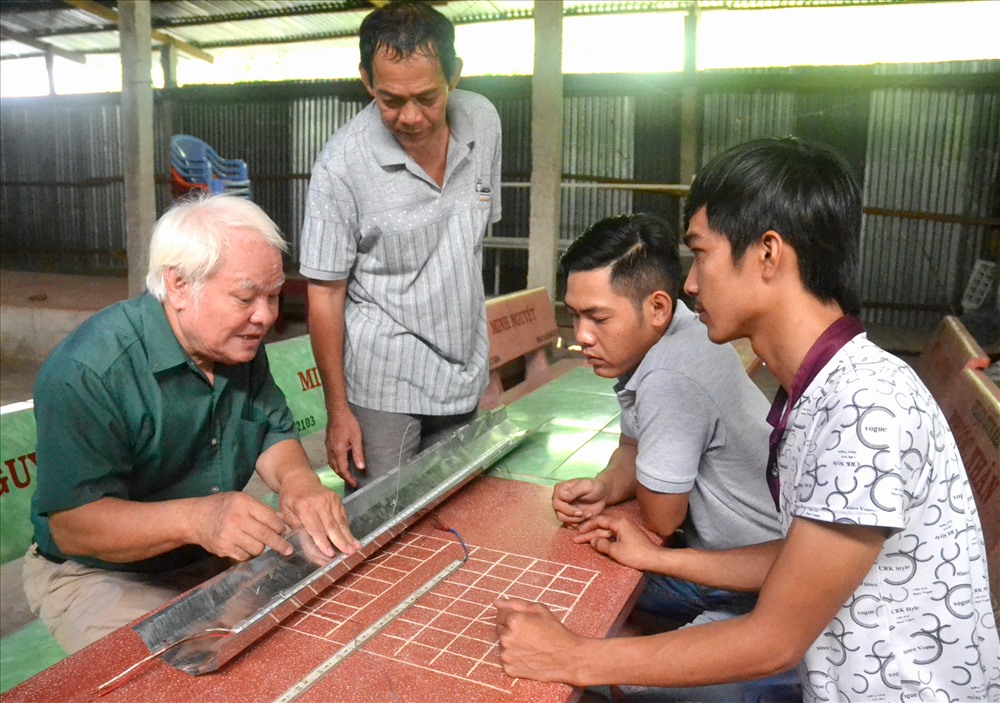 TS Nguyễn Văn Khải hướng dẫn hộ dân trên đỉnh Núi Cấm (An Hảo, Tịnh Biên) tự lắp ráp đèn LEB. Ảnh: Lục Tùng
