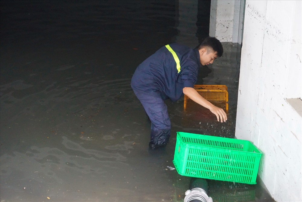 Lực lượng cứu hộ vừa bơm nước vừa vớt rác cho khỏi tắc ống bơm.
