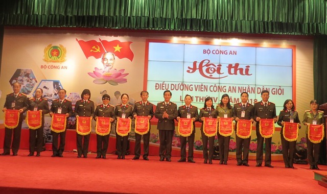 Thiếu tướng Nguyễn Đức Minh - Phó cục trưởng Cục công tác Đảng và công tác chính trị Bộ Công an tặng cờ lưu niệm cho các CĐCS có thí sinh dự thi. Ảnh: Xuân Trường