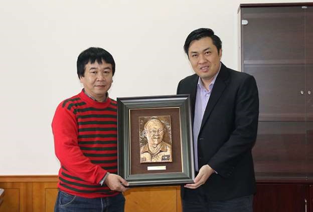 Phó Chủ tịch VFF Cao Văn Chóng nhận món quà chuyển cho HLV Park Hang-seo từ người đại diện của tác giả Nguyễn Văn Hoà. Ảnh: VFF