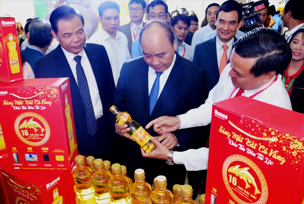 Thủ tướng Nguyễn Xuân Phúc thăm gian hàng của Tập đoàn Sao Mai, đơn vị đi đầu trong việc tận dụng mỡ cá tra làm dầu ăn cao cấp và điện năng lượng mặt trời. Ảnh: Bảo Trung