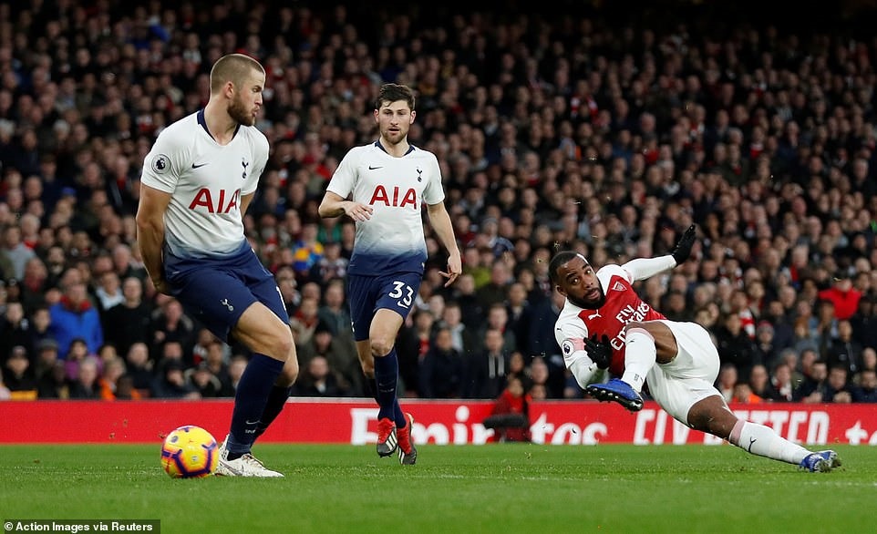 Cú đá của Lacazette (áo đỏ trắng) đưa bóng chạm nhẹ Eric Dier trước khi đi vào lưới đội khách. Ảnh: Reuters.