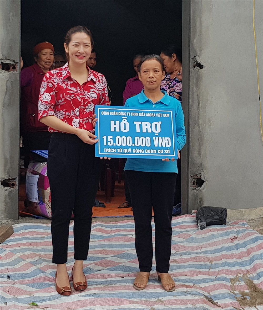 Đại diện CĐ Cty TNHH giầy ADORA Việt Nam trao tiền hỗ trợ cho gia đình chị Tống Thị Lan. Ảnh: NT