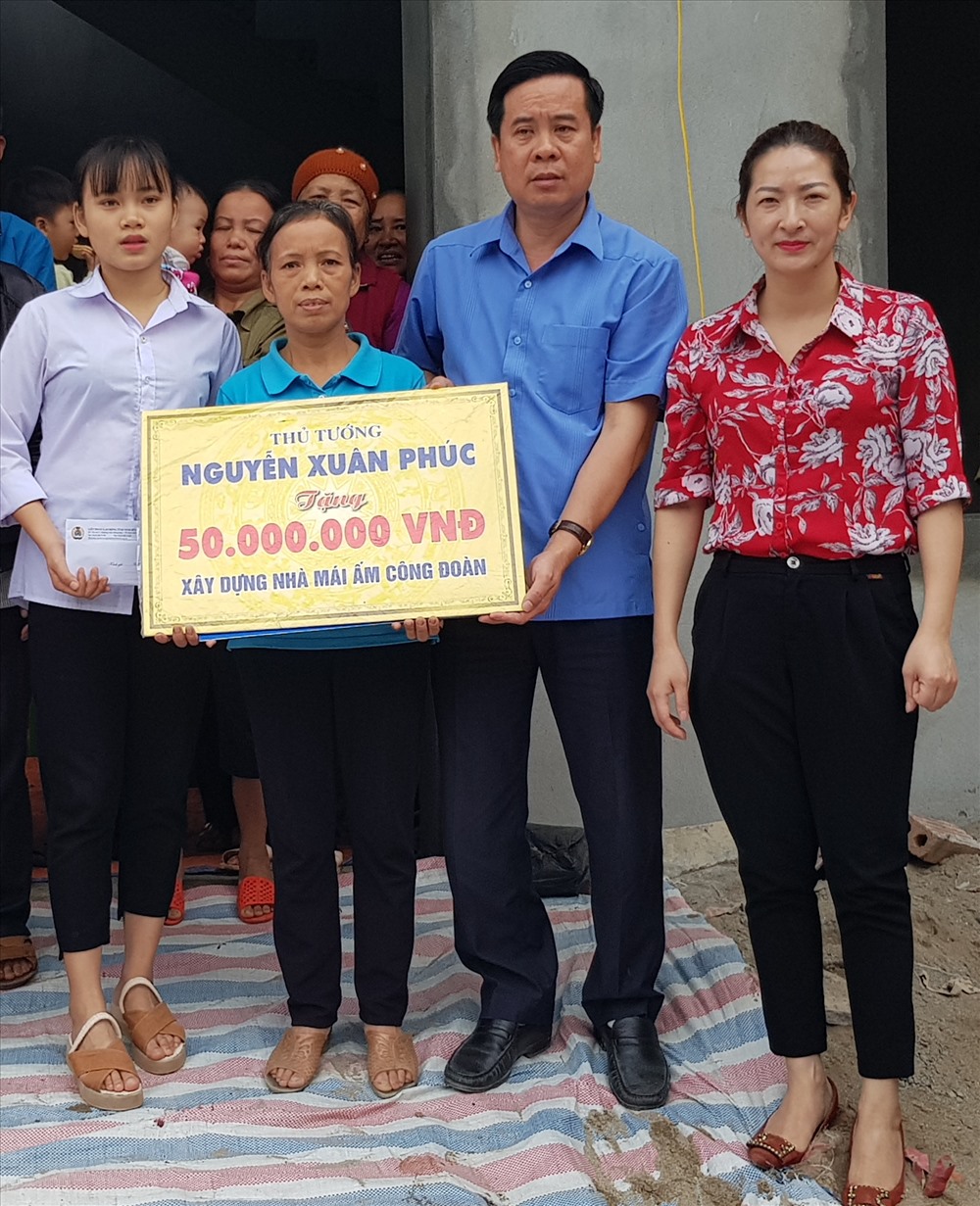 Đồng chí Dương Đức Khanh, Chủ Tich LĐLĐ tỉnh Ninh Bình trao tiền hỗ trợ cho gia đình chị Tống Thị Lan. Ảnh: NT