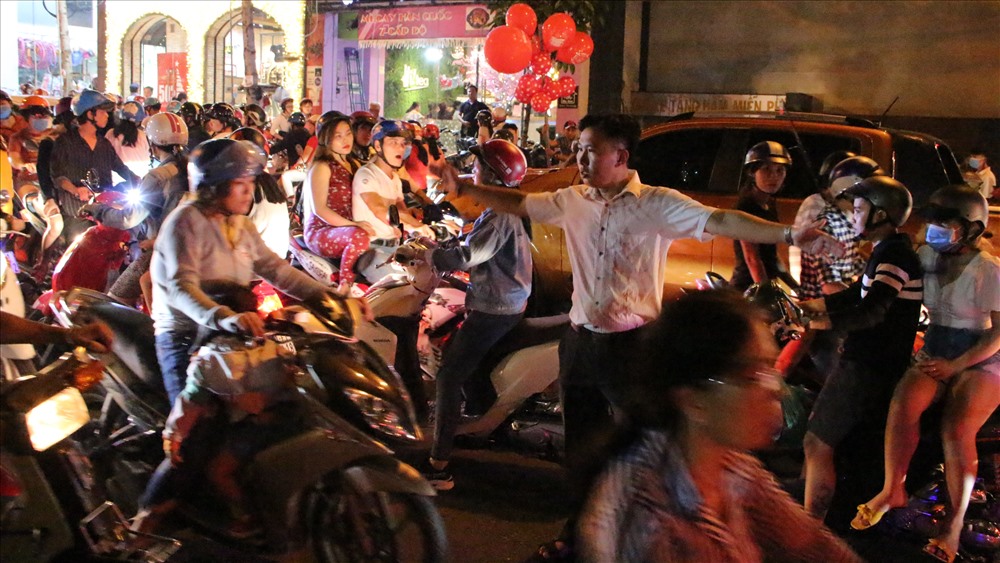 Một người dân phải xuống đường hướng dẫn các phương tiện di chuyển để gỡ rối khu vực đường giao nhau.