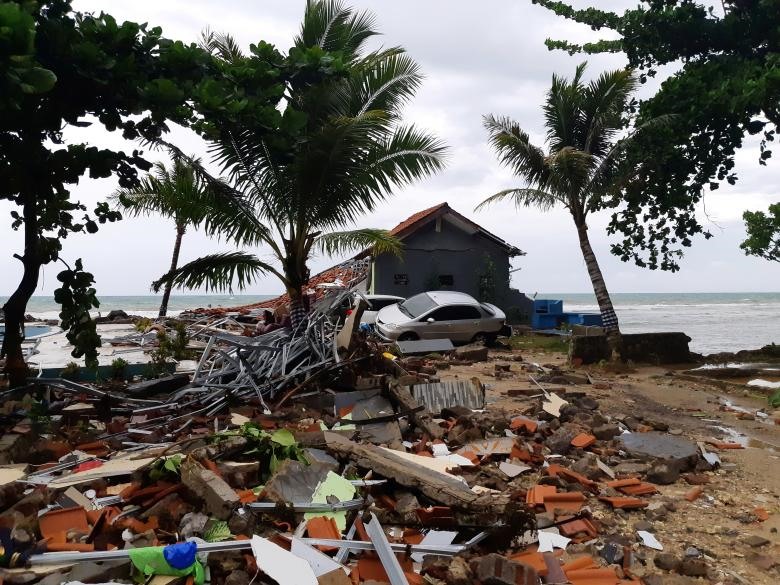 Một chiếc ô tô nằm giữa đống đổ nát sau khi sóng thần tấn công bãi biển Carita ở Pandeglang, tỉnh Banten, Indonesia.