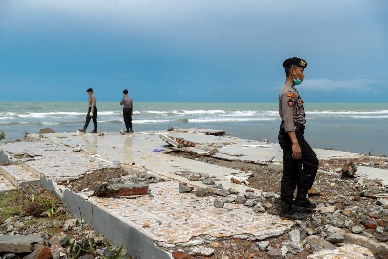 Các sĩ quan cảnh sát đang tìm kiếm các nạn nhân trong đống đổ nát của một khách sạn sau khi bị trận sóng thần ở Pandeglang, tỉnh Banten, Indonesia tràn qua.