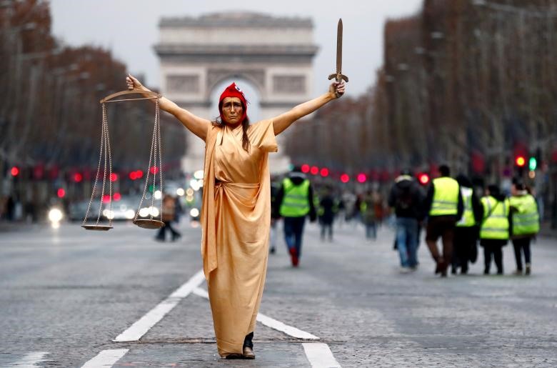 Một người phụ nữ mặc trang phục Công lý và biểu tượng cộng hòa Pháp “Marianne” tạo dáng trong một cuộc biểu tình của phong trào “áo vàng” trên đại lộ Champs Elysees gần Khải Hoàn Môn ở Paris, Pháp.
