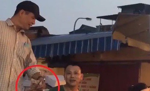 Công khai nhận tiền bảo kê ở chợ Long Biên. Ảnh: Cắt từ video VTV.