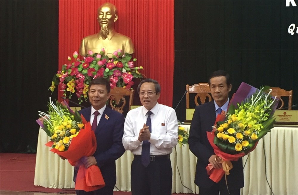 Bí thư Tỉnh ủy Quảng Bình Hoàng Đăng Quang tặng hoa nguyên Chủ tịch UBND tỉnh Quảng Bình Nguyễn Hữu Hoài (bên trái) và Tân Chủ tịch UBND tỉnh Quảng Bình Trần Công Thuật. Ảnh: Lê Phi Long