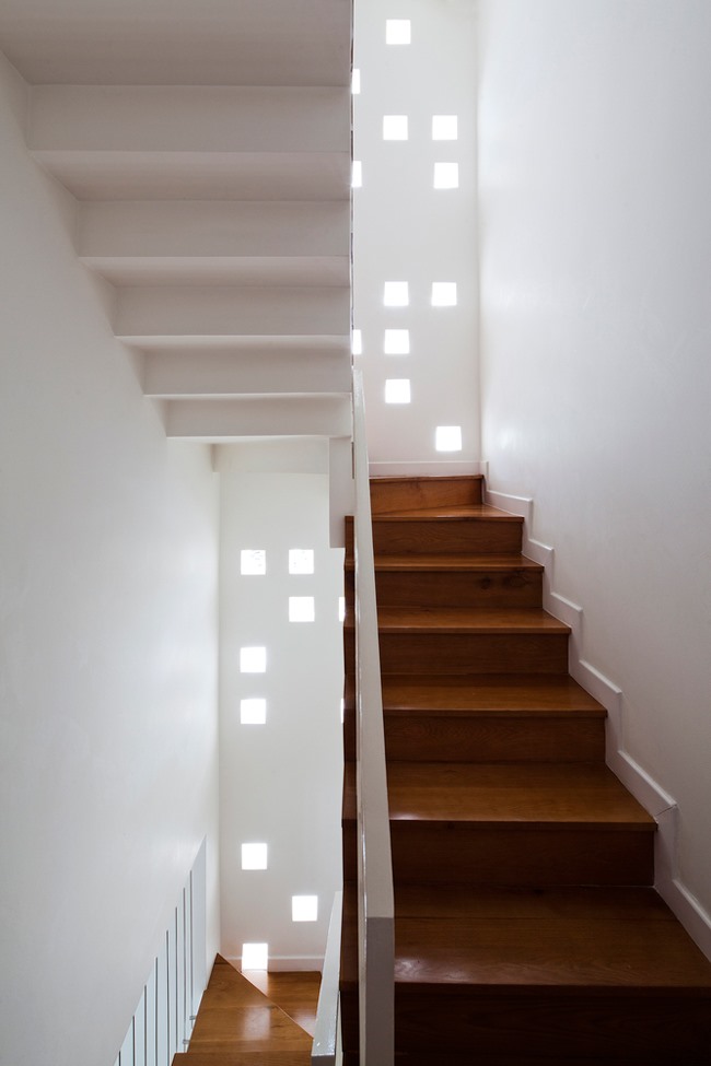 Những ô sáng nhỏ dọc các tầng được bố trí ở khu vực cầu thang lấy ánh sáng tự nhiên cho cả căn nhà.