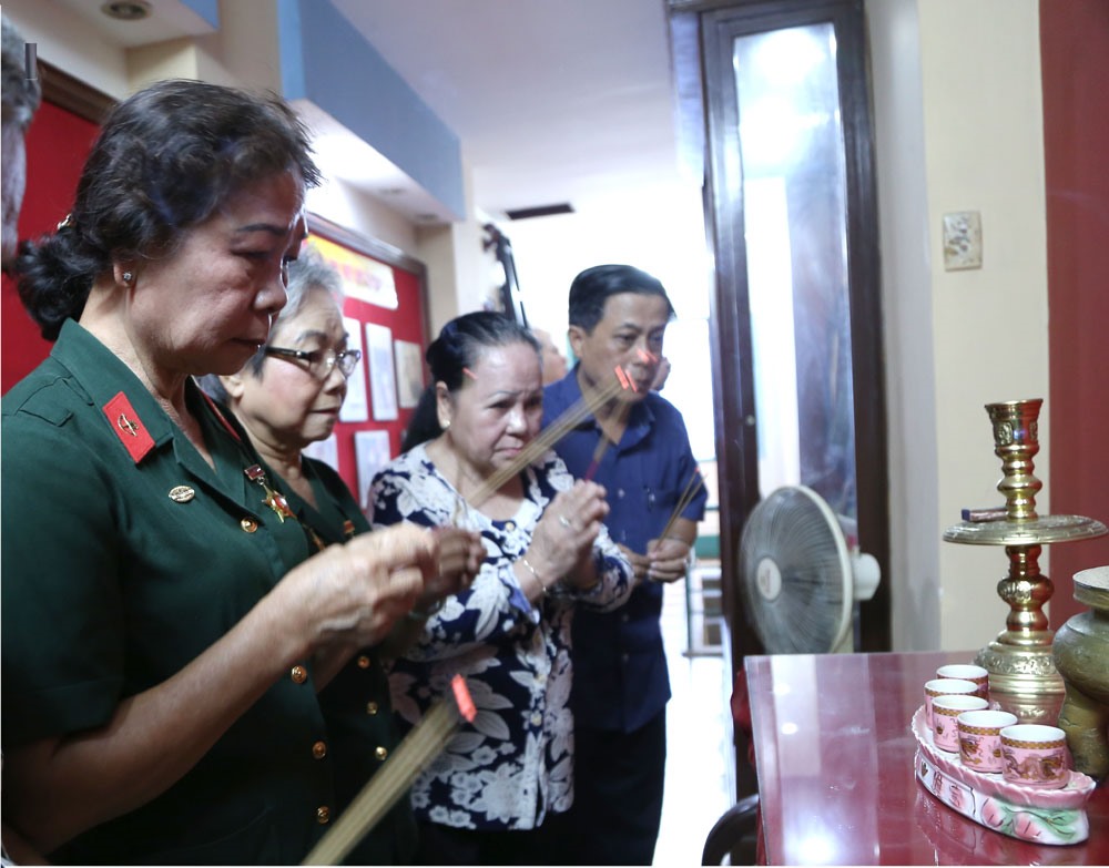 Bà Chín Nghĩa và vợ con ông Trần Văn Lai (thứ 3 và 4 từ trái qua) thắp hương cho các đồng đội tại căn hầm