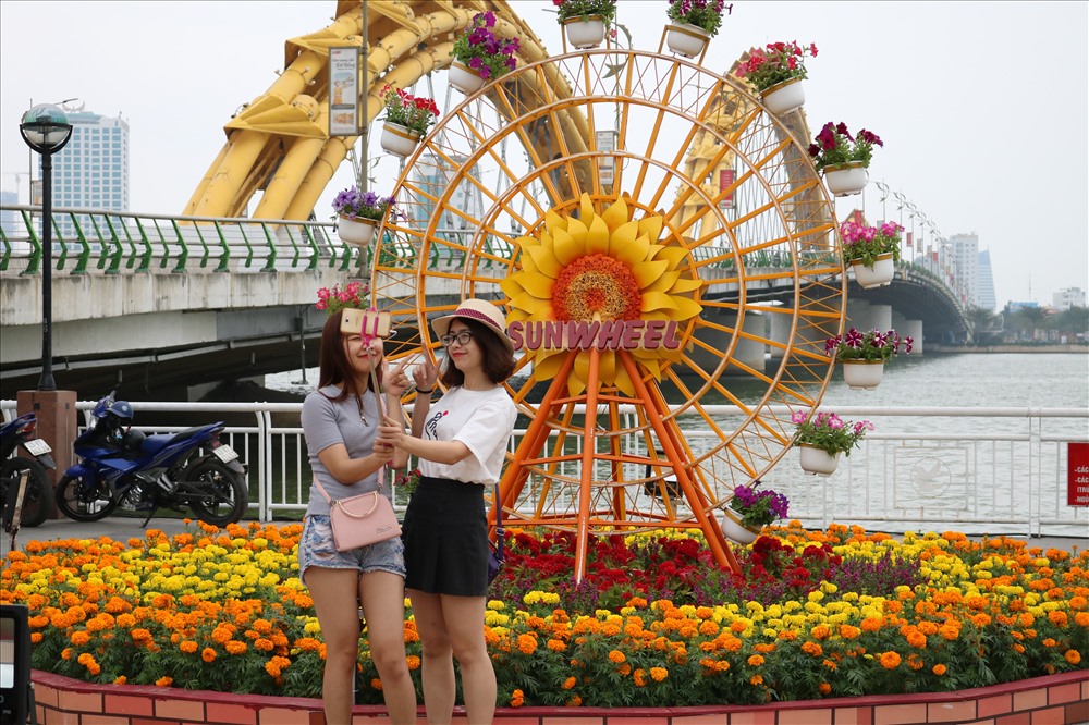 Các bạn trẻ tranh thủ check-in, chụp ảnh trước thềm xuân về. Ảnh: Trâm Nguyễn