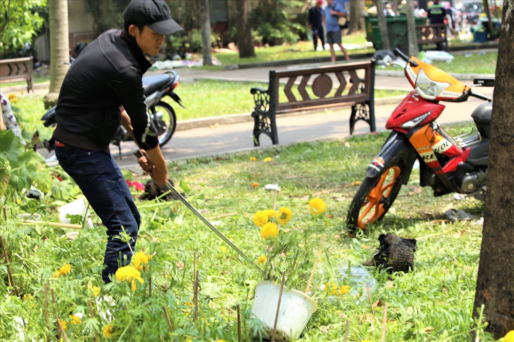 Như không muốn những chậu hoa của mình còn nguyên vẹn rơi vào tay những người khác, anh Tùng cùng bạn tiếp tục đập nốt. Ảnh: Trường Sơn