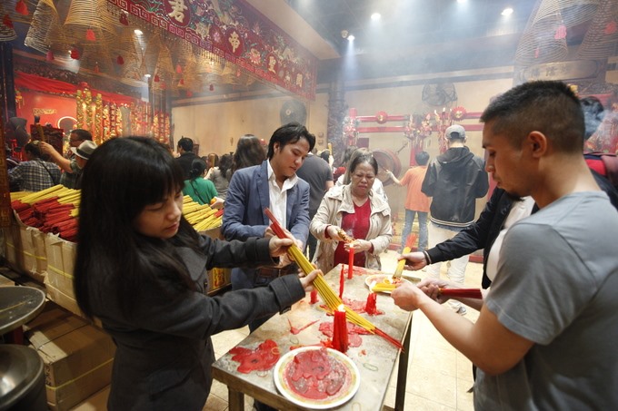 Người dân châm lửa từng bó hương đem thắp tại các gian.