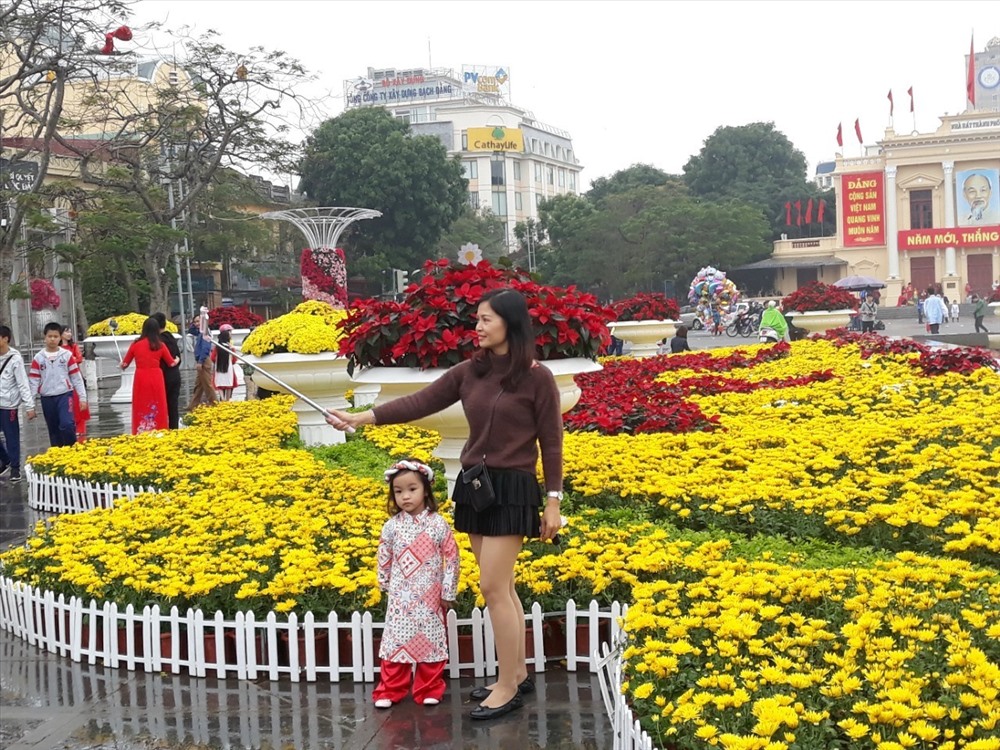 Trẻ nhỏ được bố mẹ dẫn đi chụp ảnh xuân
