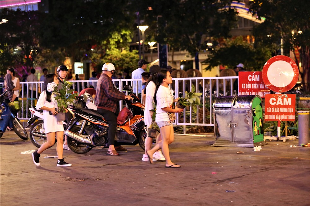 Ở ngoài đường, nhiều người vẫn kiên trì đợi các xe hoa đi ra để được những chậu hoa mà mình thấy là còn có thể sử dụng được. Ảnh: Trường Sơn
