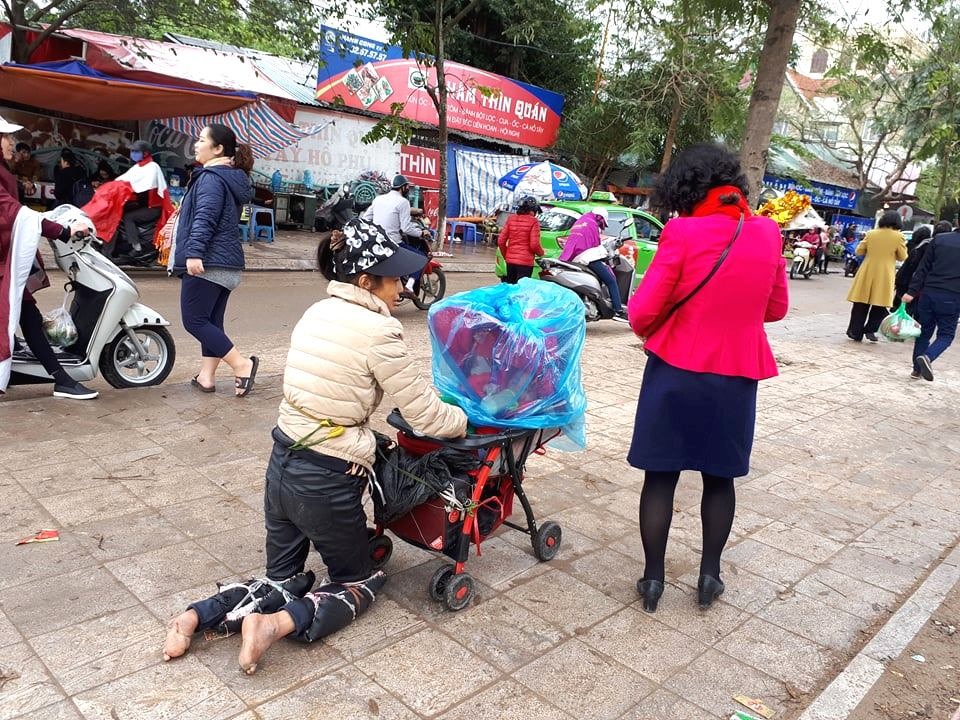 Trời mưa, người mẹ vẫn mang theo con nhỏ đi xin tiền.