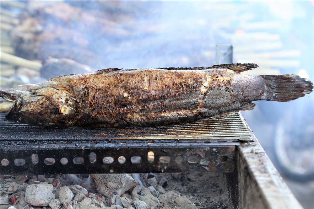 Những chú cá lóc cỡ lớn, dao động từ khoảng 1kg trở lên được chủ hàng nhập về từ các chợ đầu mối rồi nướng. Nếu như ngày thường, cá phải được làm sạch thì ngày vía Thần Tài phải để nguyên cả ruột để người dân mang về cúng. Ảnh: Trường Sơn