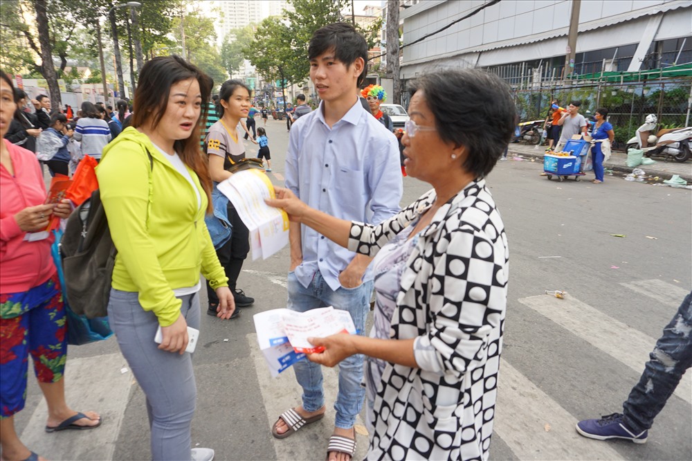 Một người phụ nữ rao bán vé chợ đen cho CĐV.