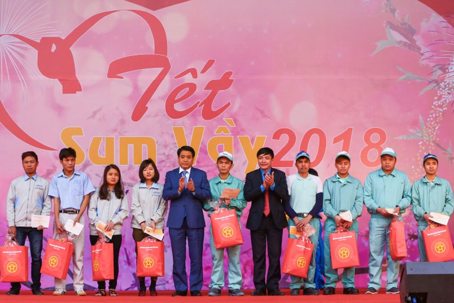Chủ tịch Tổng LĐLĐVN Bùi Văn Cường (thứ tư, phải qua) và Chủ tịch UBND TP.Hà Nội Nguyễn Đức Chung (thứ năm, trái qua) trao quà và vé xe cho công nhân. Ảnh: SƠN TÙNG