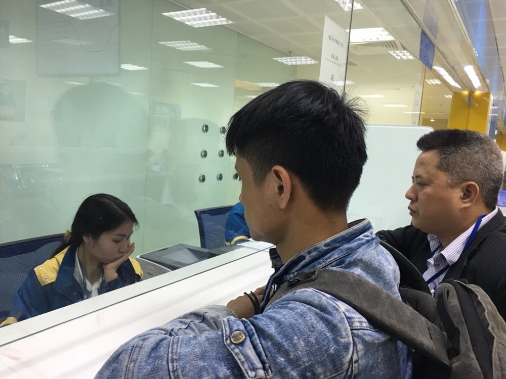 Anh Chính và đại diện Cty Gia Vi làm thủ tục nhận thi hài bà Bình. Ảnh: V.L