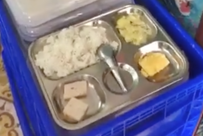 Suất cơm được cho là giá 13.000 đồng chỉ có 1 miếng trứng, 2 miếng chả mỏng và khoai tây khiến nhiều phụ huynh bức xúc. Ảnh cắt từ clip.