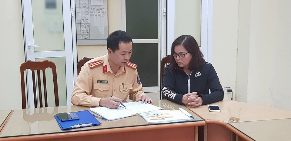 Nữ tài xế làm việc với cảnh sát giao thông sau khi vi phạm.